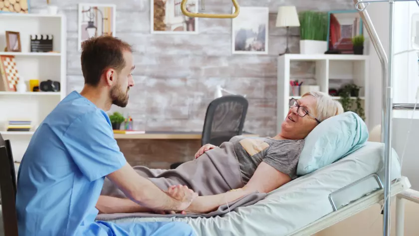 Infirmier auprès d'un patient alité à domicile