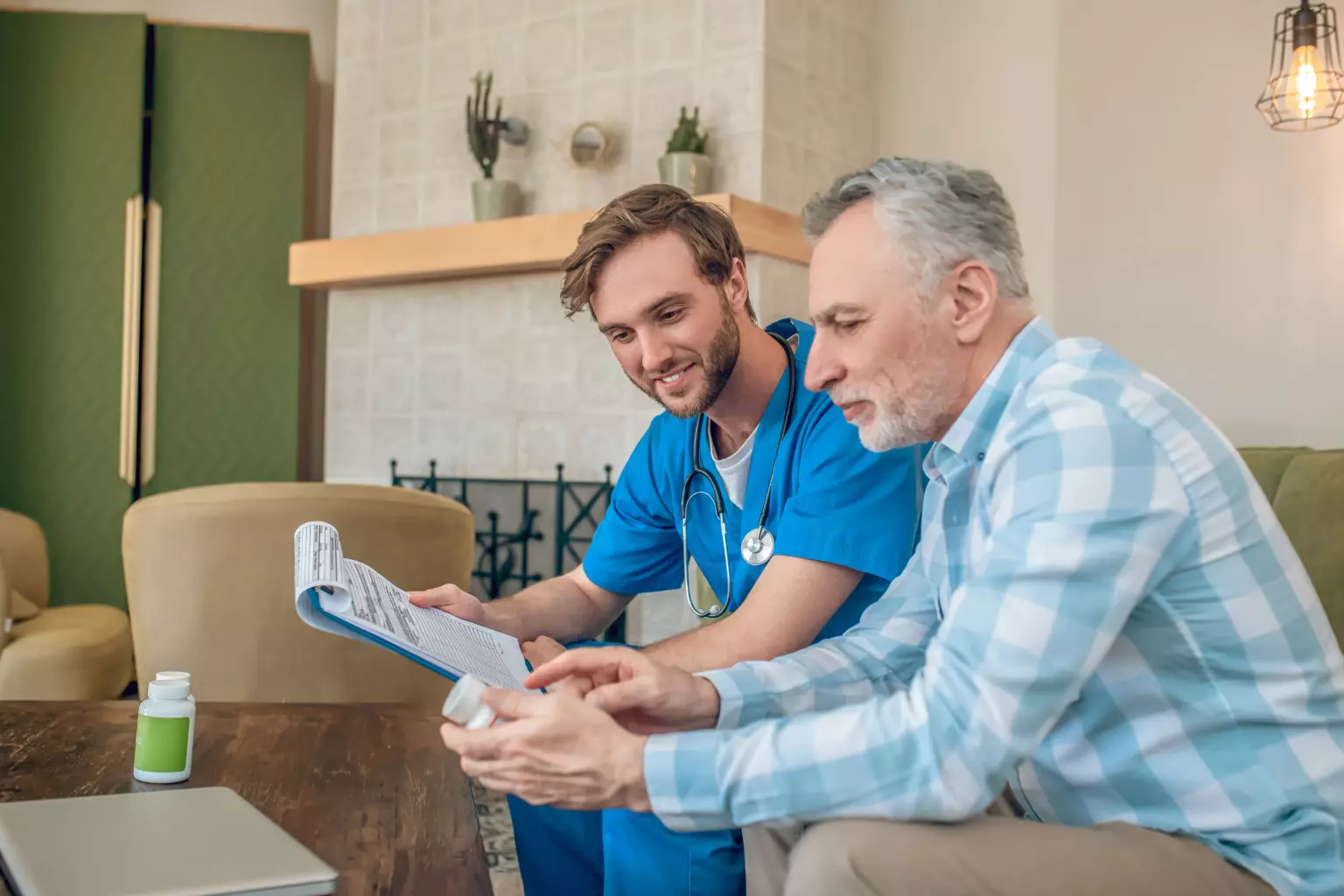 Un soignant aide un patient à lire une ordonnance et à comprendre son traitement.